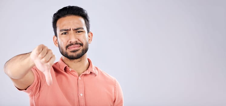 Fail, thumbs down and portrait of Asian man in studio isolated on a gray background mockup. Dislike hand gesture, emoji and face of sad male model with sign for disagreement, rejection or bad review