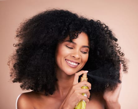 Model, happy or afro hair spray on isolated studio background in frizz control, curly management or oil treatment. Black woman smile, face or natural haircare product for grooming or texture wellness.