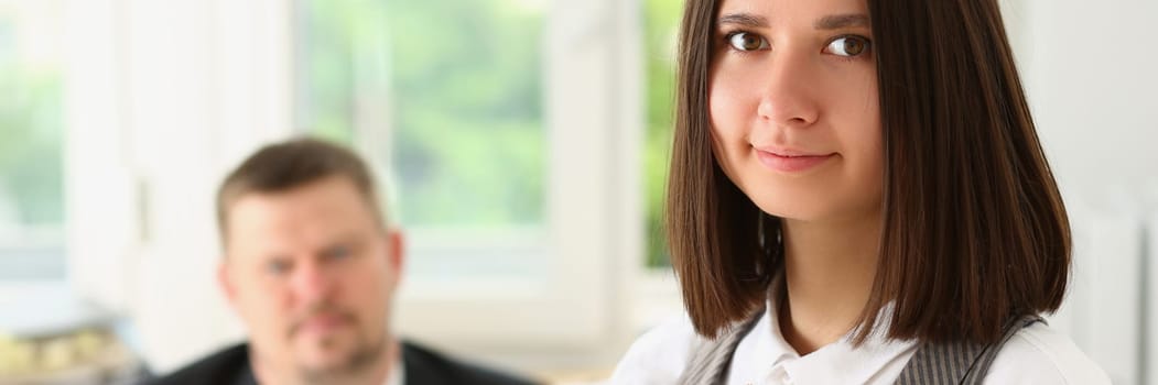 Boss fires young woman from office job. Fired woman with box of things in office