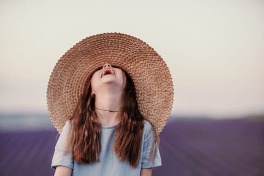 Girl lavender field. Laughing girl in a blue dress with flowing hair in a hat stands in a lilac lavender field.