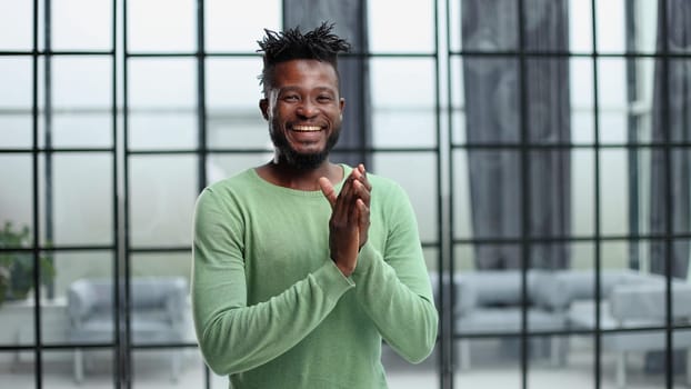 footage of a happy young businessman clapping in a modern office.
