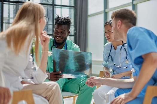Young group of oral surgeons looking at x-ray while preparing for surgery procedure.