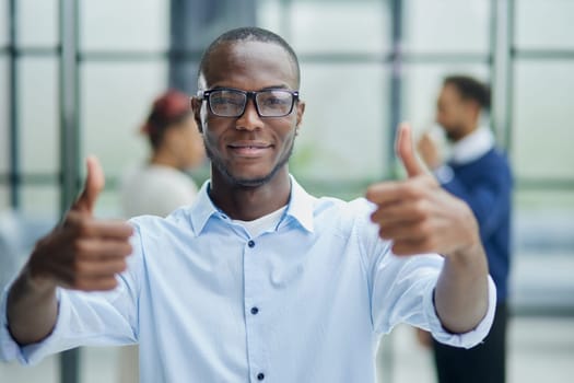 Portrait of happy afroamerican handsome man and showing thumb up gesture