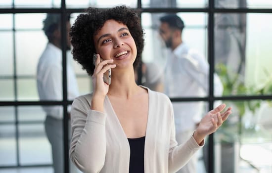 Businesswoman sitting in office, talking on the phone
