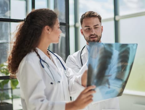 Concentrated male doctor looking at x-ray picture of spine