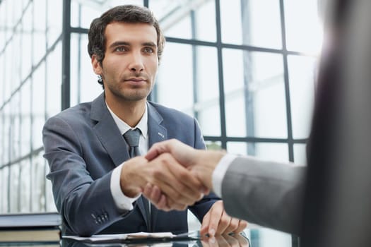 young businessman shaking hands with his partner