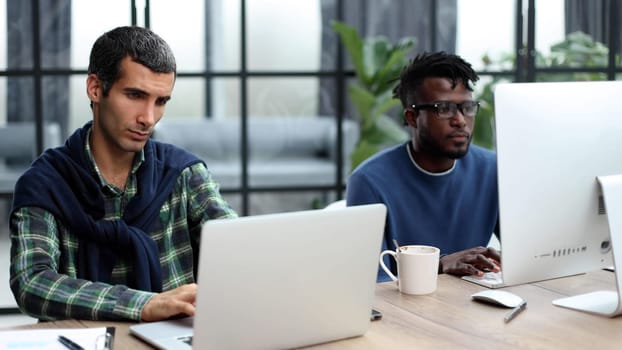 Managers with laptop sitting in modern office