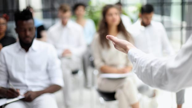 Selective focus of young businesswoman together with interracial colleagues during seminar