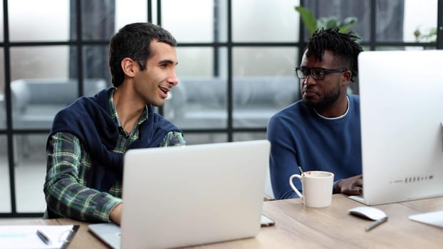 Smiling beautiful businesspeople working on laptop in modern office lobby