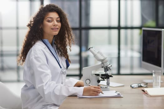 Attractive female scientist looking through a microscope