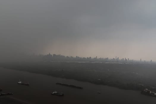 Bangkok, Thailand - May 28, 2023 - Misty Landscape of city skyscrapers covered before raining. Heavy dense smog fot during afternoon that Bangkok city cannot be seen clearly, Aerial top view of city on a foggy day, Space for text, No focus, specifically.