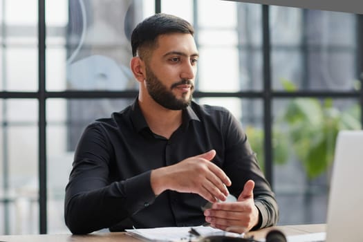 Positive businessman talking on headset at a computer