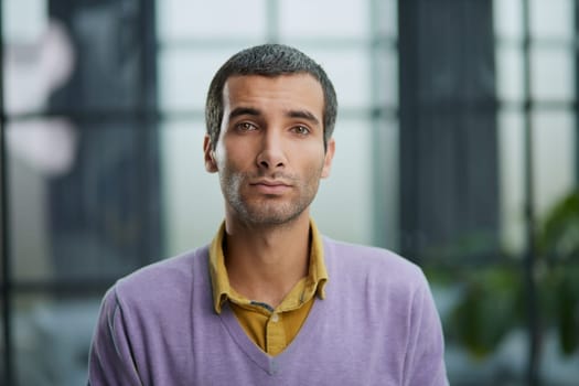 Portrait of businessman standing in office while working day
