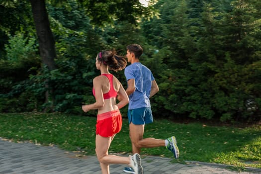 Portrait of cheerful caucasian couple running outdoors. Sport family