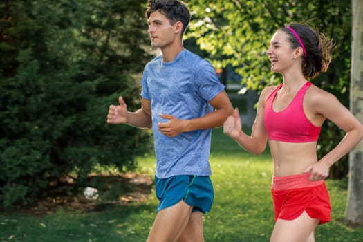 Portrait of cheerful caucasian couple running outdoors. Sport family