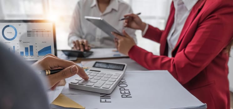 Business People Meeting using laptop computer,calculator,notebook,stock market chart paper for analysis Plans to improve quality next month. Conference Discussion Corporate Concept