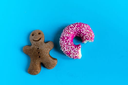 Donut with hazelnuts on a blue background, close up