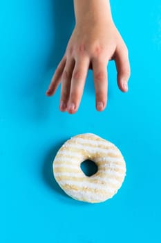 Donut with hazelnuts on a blue background, close up