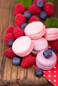Macaroon with raspberries cookies on a wooden background