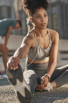 Black woman, stretching legs and streaming audio yoga fitness podcast before run. Cardio training, healthy lifestyle and listening to music for motivation, peace and relax in workout on city street.