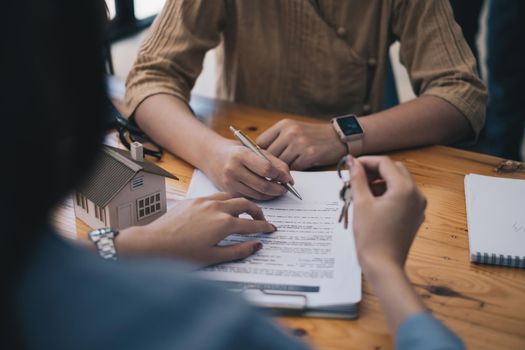 Close up of Business woman pointing and signing agreement for buying house. Bank manager and real estate concept