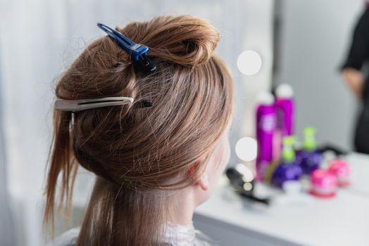 Young woman sitting in beauty hair salon style and waiting for hairdresser to make a hairdo