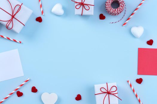 Valentine's Day, Mother's day art design concept - Red, white wrapped gift box isolated on pastel light blue color background, flat lay, top view.