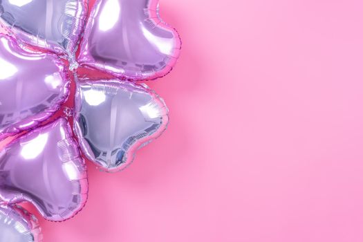 Valentine's Day minimal design concept - Beautiful real heart shape foil balloon isolated on pale pink background, top view, flat lay, overhead above photography.