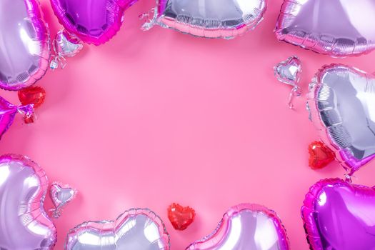 Valentine's Day minimal design concept - Beautiful real heart shape foil balloon isolated on pale pink background, top view, flat lay, overhead above photography.