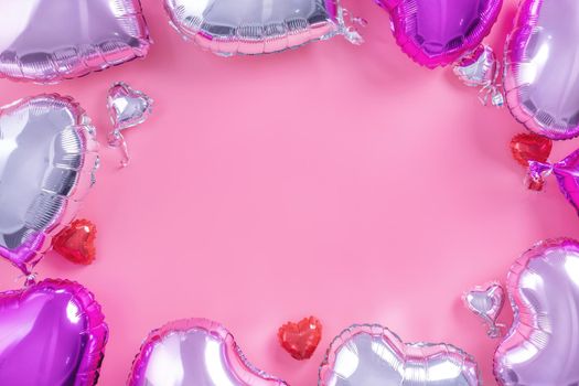 Valentine's Day romantic design concept - Beautiful real heart shape foil balloon isolated on pale pink background, top view, flat lay, overhead above photography.