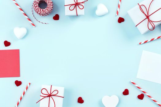 Valentine's Day, Mother's day art design concept for promotion - Red, white wrapped gift box isolated on pastel light blue color background, flat lay, top view.