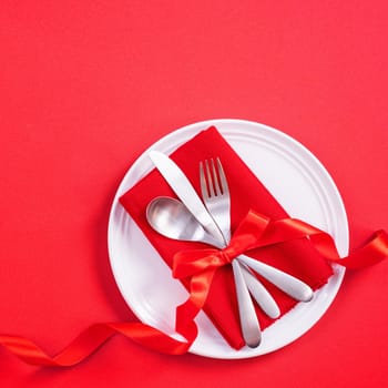 Valentine's Day meal design concept - Romantic plate dish set isolated on red background for restaurant, holiday celebration promotion, top view, flat lay.