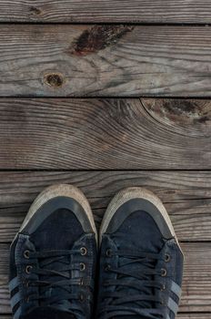 Front parts of pair of blue sneakers on dry wooden planks background. top view