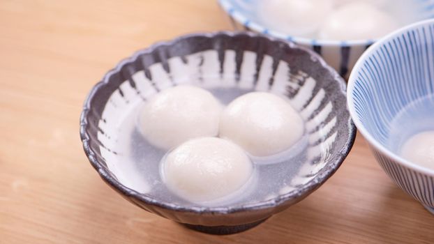 Tang yuan, tangyuan, yuanxiao in a small bowl. Delicious asian traditional festive food rice dumpling balls with stuffed fillings for Chinese Lantern Festival, close up.