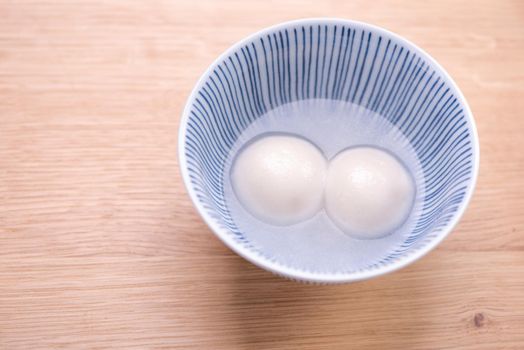 Delicious tang yuan, yuanxiao in a small bowl. Traditional festive food rice dumplings ball with stuffed fillings for Chinese Lantern Festival, close up.