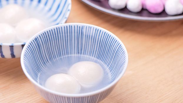 Tang yuan, tangyuan, yuanxiao in a small bowl. Delicious asian traditional festive food rice dumpling balls with stuffed fillings for Chinese Lantern Festival, close up.