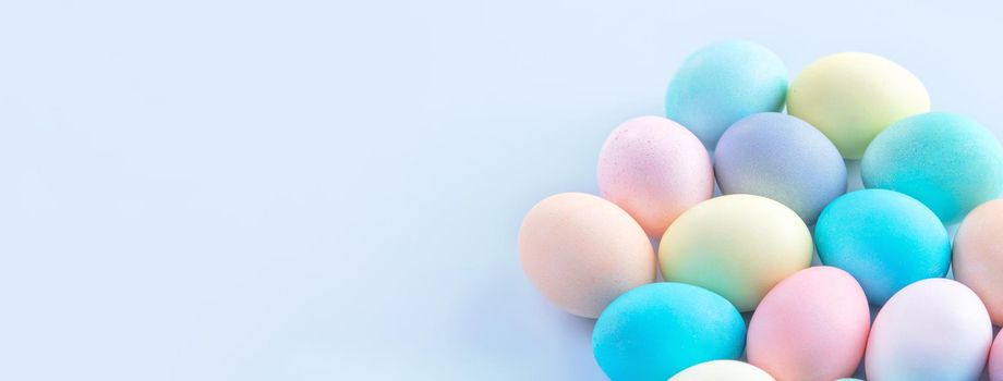 Colorful Easter eggs dyed by colored water isolated on a pale blue background, design concept of Easter holiday activity, close up, copy space.