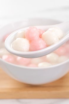 Tang yuan, tangyuan, delicious red and white rice dumpling balls in a small bowl. Asian traditional festive food for Chinese Winter Solstice Festival, close up.