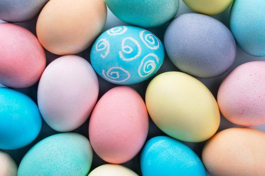 Colorful Easter eggs dyed by colored water isolated on a pale blue background, design concept of Easter holiday activity, close up, copy space.