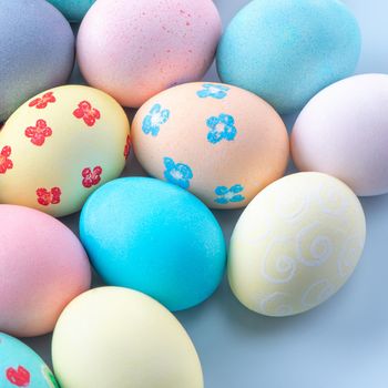 Colorful Easter eggs dyed by colored water isolated on a pale blue background, design concept of Easter holiday activity, close up, copy space.