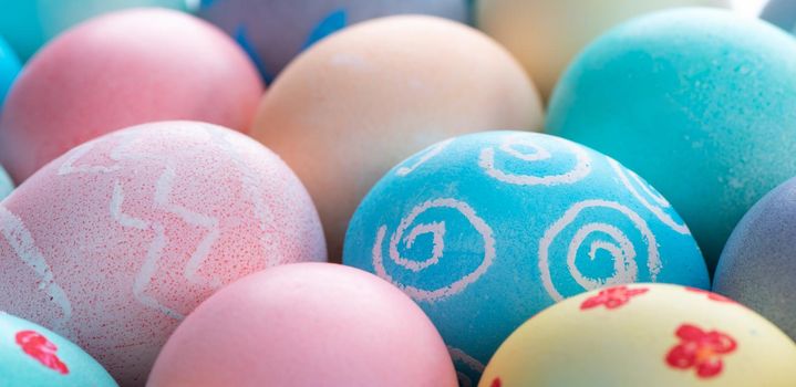 Colorful Easter eggs dyed by colored water isolated on a pale blue background, design concept of Easter holiday activity, close up, copy space.