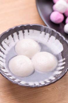 Tang yuan, tangyuan, yuanxiao in a small bowl. Delicious asian traditional festive food rice dumpling balls with stuffed fillings for Chinese Lantern Festival, close up.