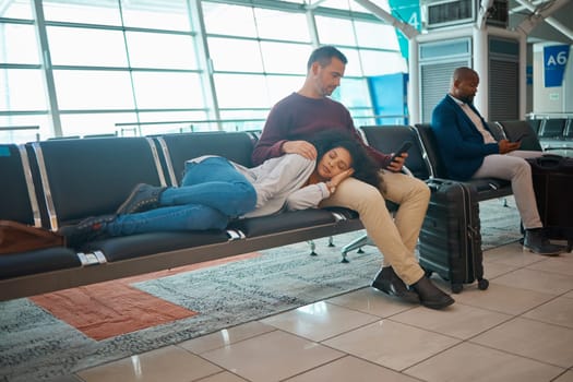 Tired, delay and couple at the airport for a flight, waiting and sitting in the lounge on a phone. Immigration, relax and woman sleeping with a man reading on a mobile while traveling for holiday.