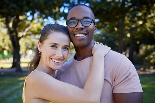 Couple hug, date outdoor and portrait with nature, love and commitment in park with interracial relationship. Trust, support and happy people, black man and woman with smile on face and content.