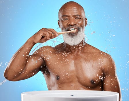 Dental, brushing teeth and black man with toothbrush for teeth, cleaning with toothpaste for fresh breath and healthy gums against blue background. Water, splash and hygiene with dental care and oral.