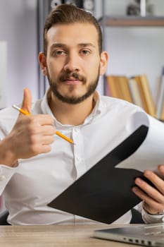 Businessman ceo reading business contract, planning project, analyzing resume, satisfied with good paperwork results. Man at office looking at camera talking, online conversation interview. Vertical
