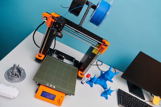 Modern 3d printer for creating 3d models and materials on the table in the laboratories next to the computer. High quality photo