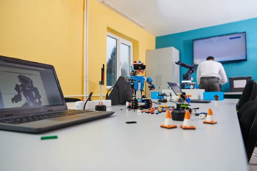 A student testing his new invention of a robotic arm in the laboratory, showcasing the culmination of his research and technological prowess