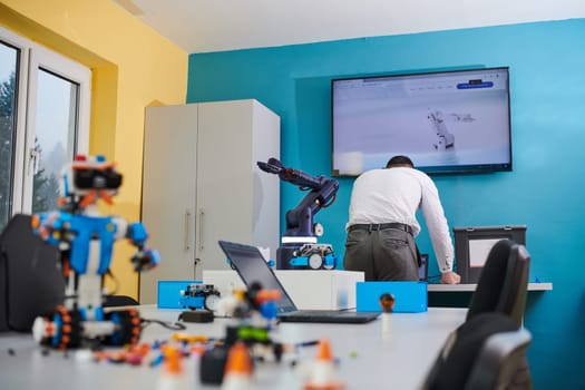 A student testing his new invention of a robotic arm in the laboratory, showcasing the culmination of his research and technological prowess