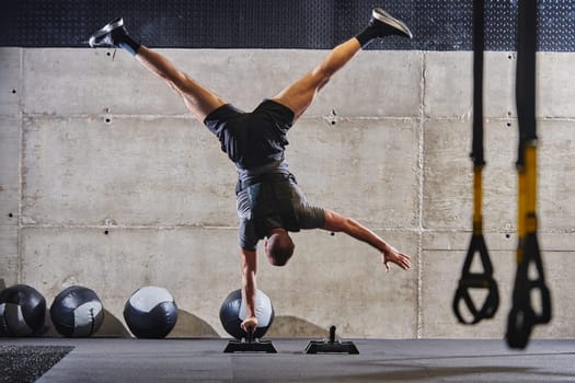 A muscular man in a handstand position, showcasing his exceptional balance and body control while performing a variety of exercises to enhance his overall body stability and strength in a modern gym.